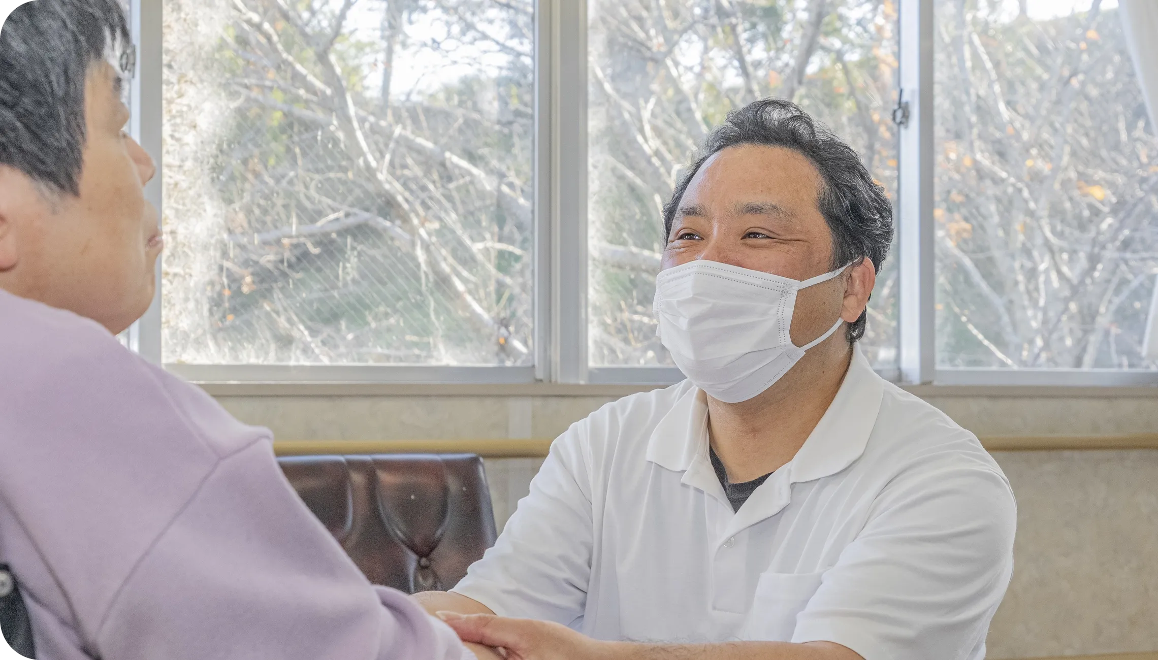 手をつないで散歩する職員と利用者